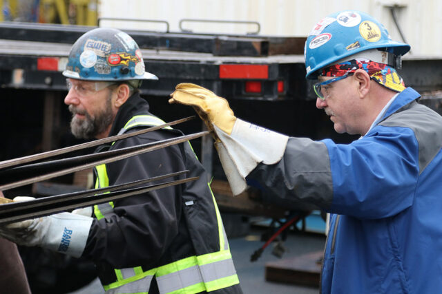 Gord Weel (359) (pictured left) and Greg Blender (CBI) working together unloading the tank shell.