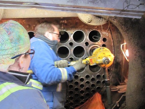 Barry Dobrensky rolling 5” flue tubes in the smoke box under the directions of Sarah Smith